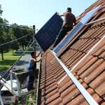 Steffen Kapelle auf dem Dach beim Anbringen der Solarmodule.
