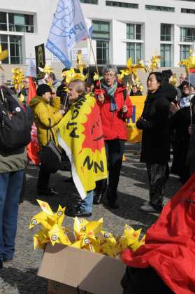 Demonstant:innen mit Flaggen auf denen die rote Sonne und der Schriftzug "Atomkraft? Nein danke" steht