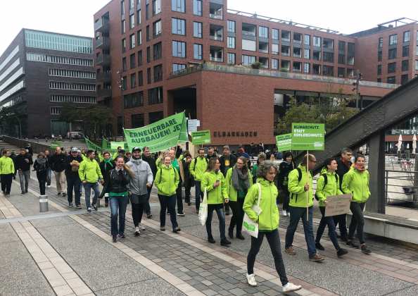 Greenpeace Energy Mitarbeitende beim Klimastreik mit Transparenten und grünen Jacken