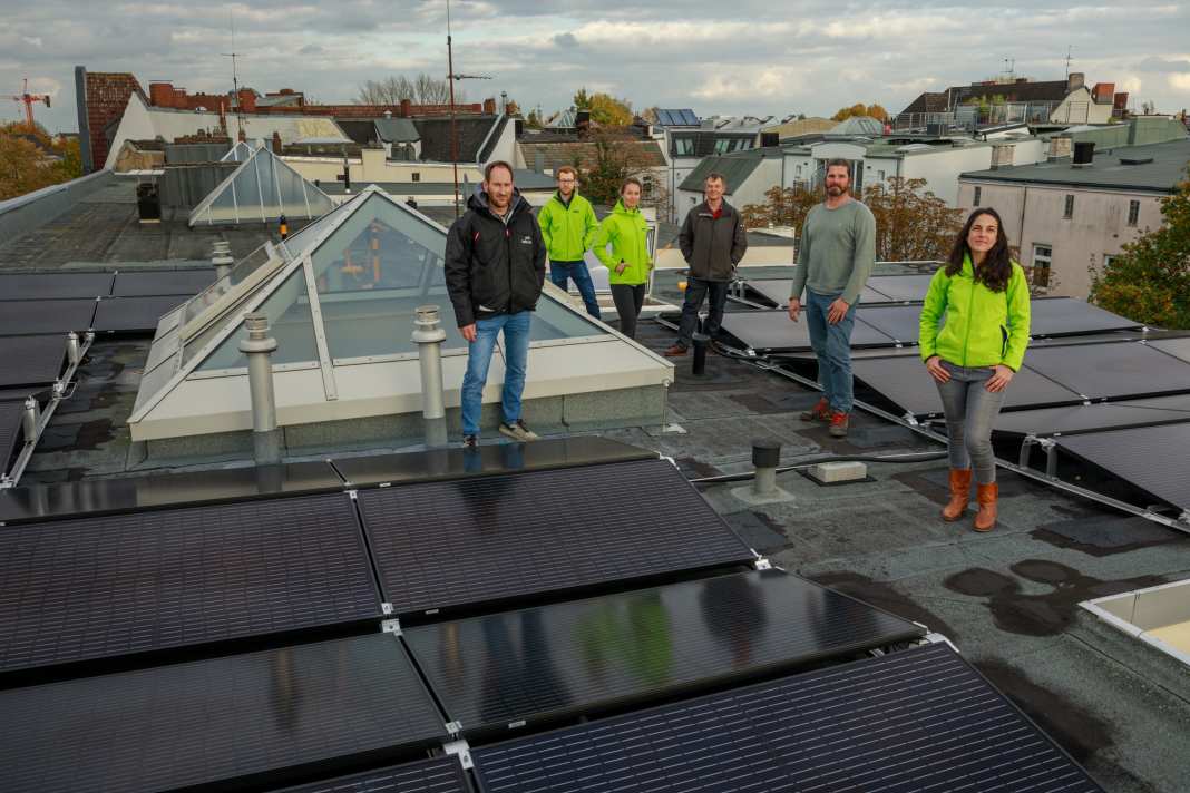 Green Planet Energy Mitarbeitende auf einem Dach mit Solaranlage für Mieterstrom.