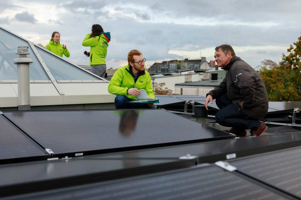 Hauseigentümer Jan Erichsen im Gespräch mit den Mitarbeiterinnen und Mitarbeitern von Greenpeace Energy