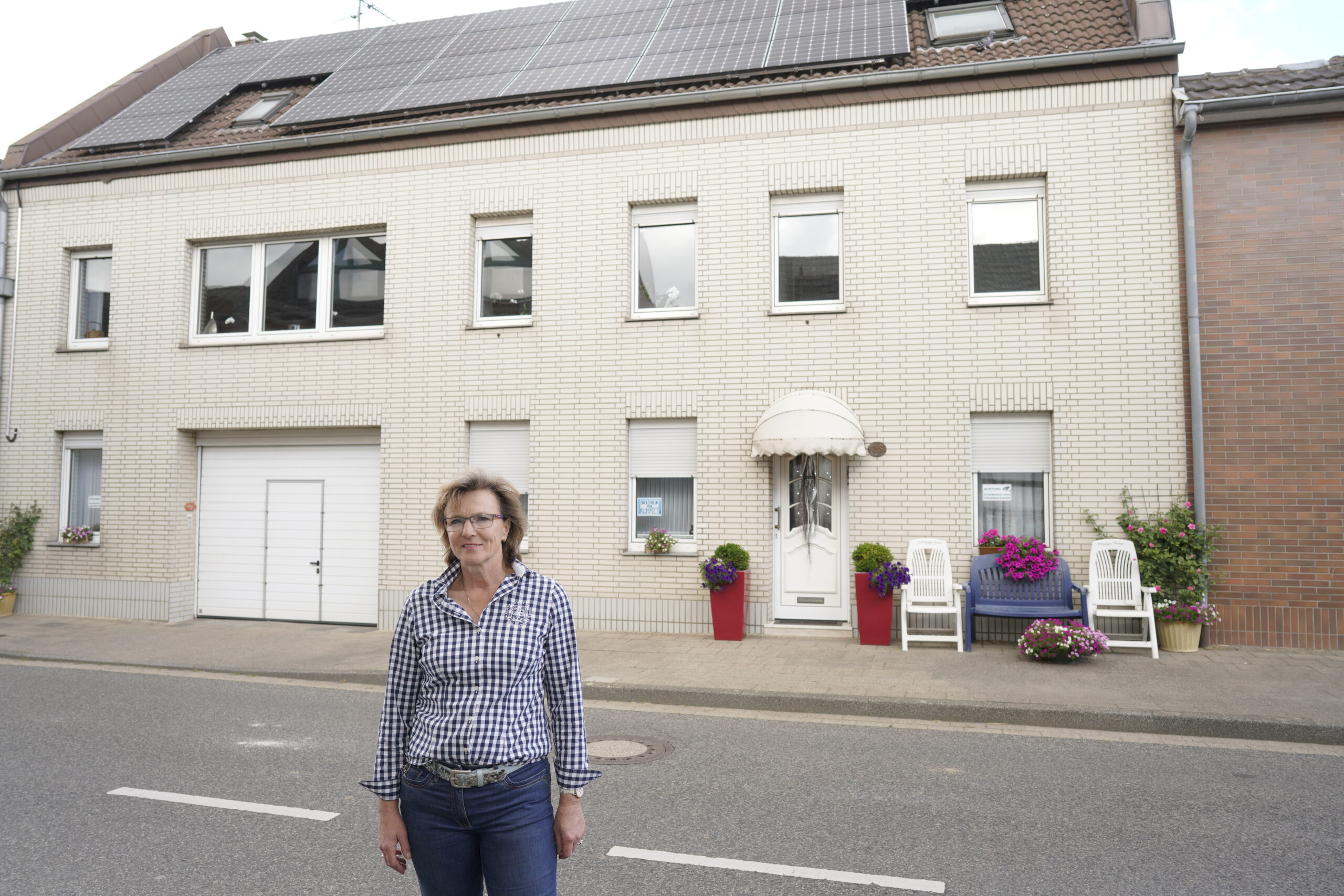 Barbara Ziemann-Oberherr vor ihrem Haus mit PV-Anlage auf dem Dach