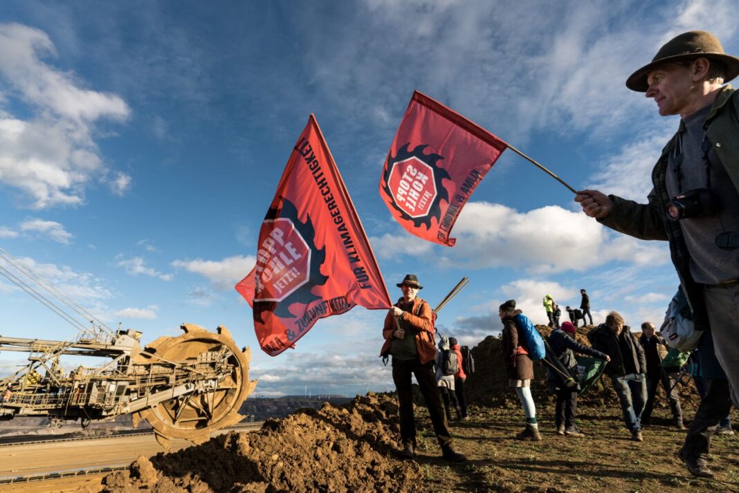 Eine Gruppe demonstrierender Menschen an der Abbruchkante des Braunkohlerevier Lützeraths.