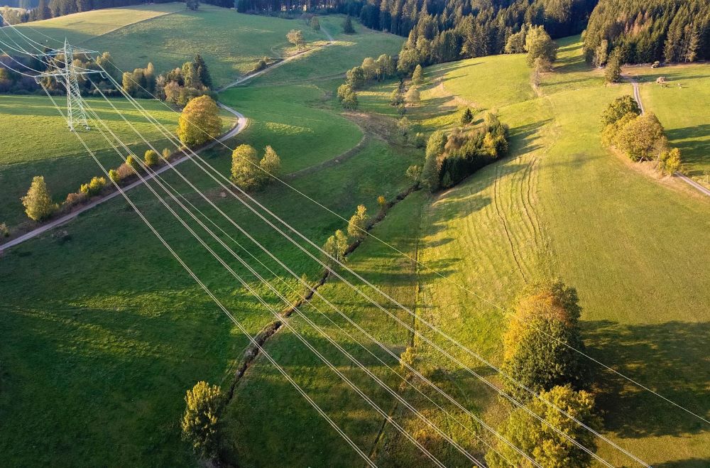 Luftbild, Hochspannungsleitungen im Feld. Landwirtschaftliche Felder und Stromleitungen.