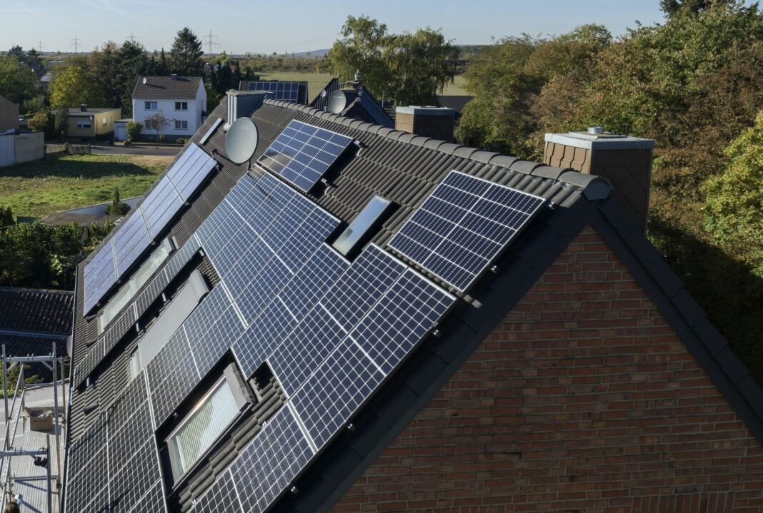 Eine PV-Anlage auf einem Mehrfamilienhaus in ländlicher Umgebung.