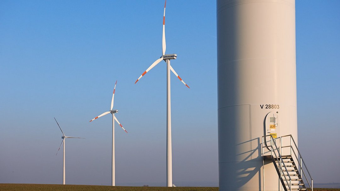 Windpark Wundersleben bei blauem Himmel: Im Voddrgrund ein angeschnittenes Windrad, im Hintergrund 3 weitere Windräder.