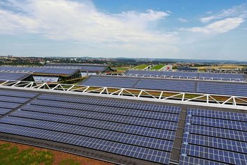 Eine PV-Anlage auf dem gewellten Dach eines Gewerbegebiets