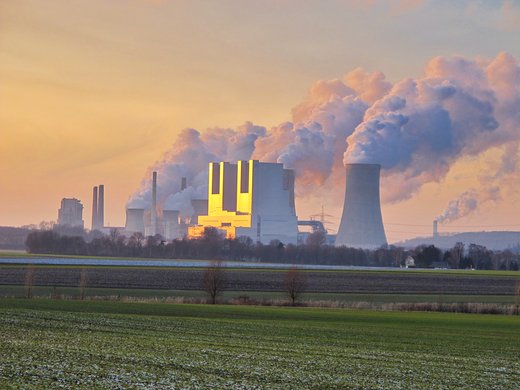 Kohlenkraftwerke in der Ferne stoßen grauen Rauch aus.