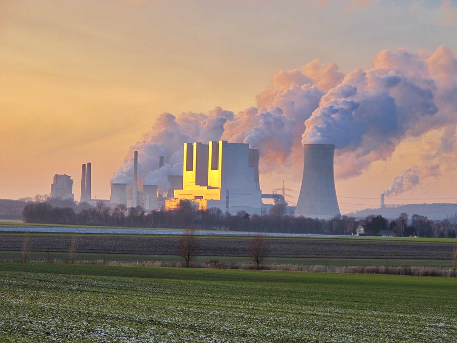 Kohlenkraftwerke in der Ferne stoßen grauen Rauch aus.