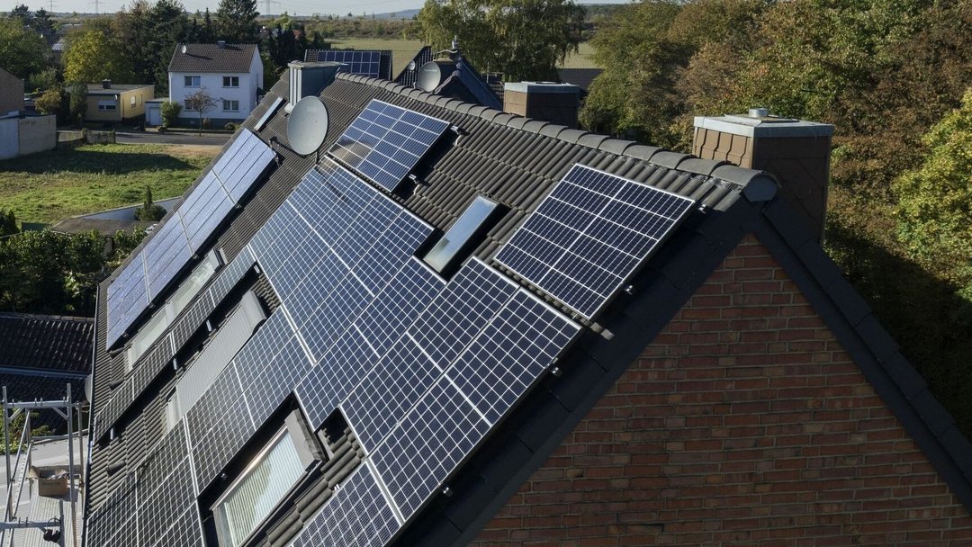 Eine PV-Anlage auf einem Mehrfamilienhaus in ländlicher Umgebung.