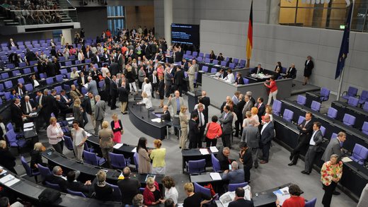 Menschen diskutieren im Bundestag stehend.