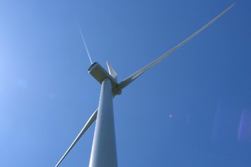 Windenergieanlage von unten nach oben fotografiert mit blauem Himmel