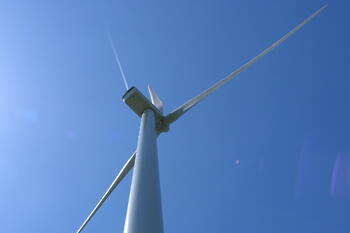 Windenergieanlage von unten nach oben fotografiert mit blauem Himmel