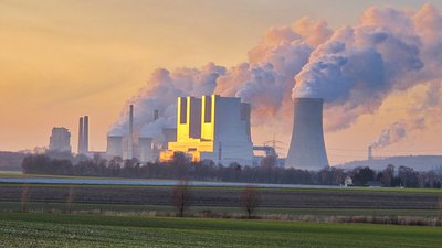 Kohlenkraftwerke in der Ferne stoßen grauen Rauch aus.