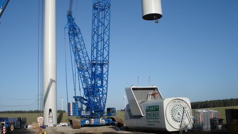 Turmelement wird mit Kran nach oben gezogen, Maschinenhaus steht auf dem Boden