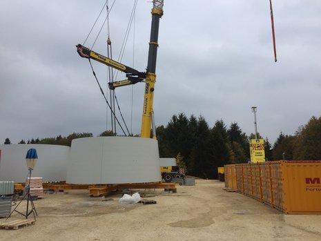 Unterer Teil eines Windkraftturms vor Kran