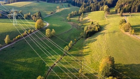 Luftbild, Hochspannungsleitungen im Feld. Landwirtschaftliche Felder und Stromleitungen.