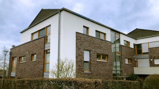 Ein modernes Mehrfamilienhaus mit weißen und Backstein-Außenwänden. 