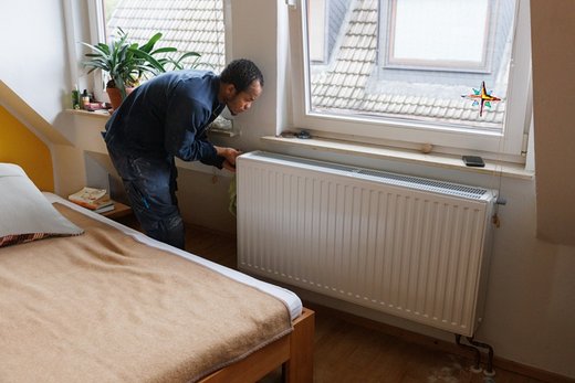 Ein Installateur vermisst einen Heizkörper bei der Wärmeplanung des Gebäudes. Foto: Jonas Wresch