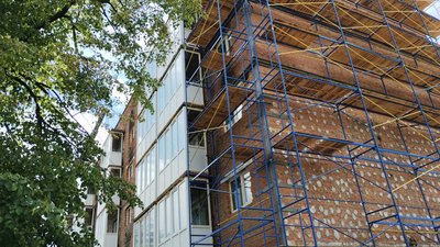 Ein Wohnhaus, wovor ein Gerüst steht