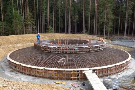 Bau einer Windkraftanlage im Wald: Rundes Betonfundament wird errichtet.
