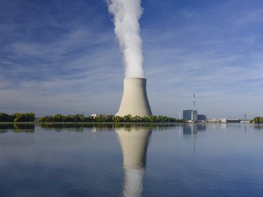 Atomkraftwerk mit Rauch hinter Wasser