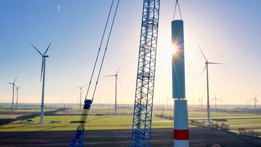 Ein Kran hebt eine große Windturbine an ihren Platz.