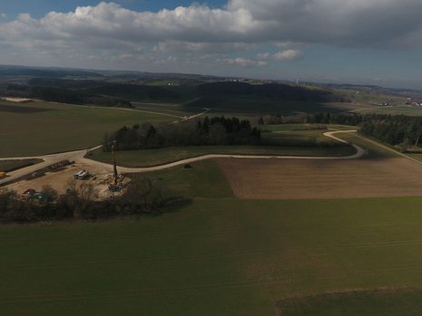 Mehrere Felder aus der Vogelperspektive. Eins der Felder ist umgegraben. Das Fundament für ein Windrad ist erkennbar.