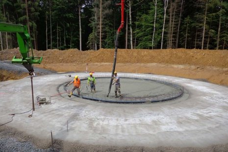 Fundament für Windkraftanlage: Beton wird in eine Grube gegossen.