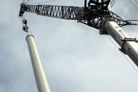 Kran hebt Turm für Windkraftanlage in die Höhe