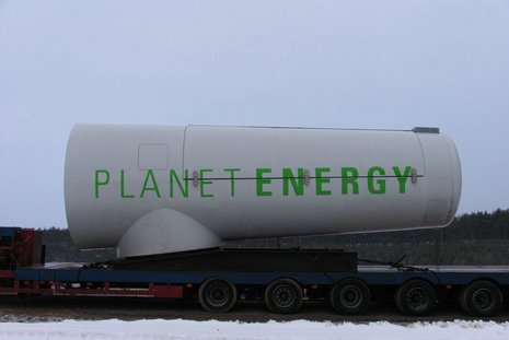 Transport eines Windkraftgenerators mit dem Planet Energy-Label auf einem Anhänger.