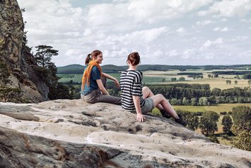 Zwei Frauen sitzen auf einem Felsen im Harz
