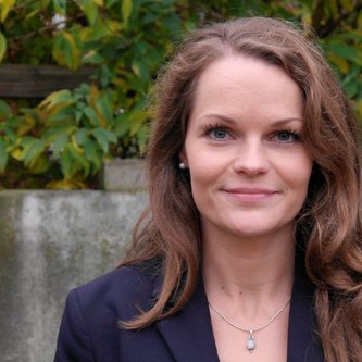 Frau mit langen Haaren schaut in die Kamera