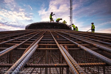 Mehrere Arbeiter arbeiten an den Fundamenten einer Windkraftanlage.