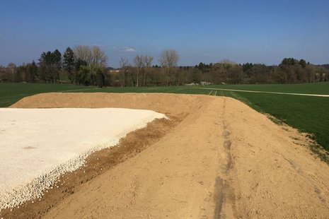 Baustelle mit grünem Park im Hintergrund.
