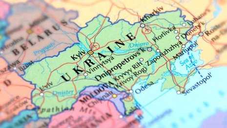 Eine farbige Landkarte zeigt die Ukraine, benachbarte Länder und Städte wie Kiew und Dnipro. Rote Linien markieren wichtige Verkehrswege. Die Karte ist stark vergrößert für Details.