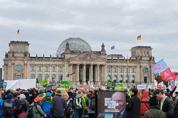 Zahlreiche Plakate und Schilder der Erneuerbaren Energien und eine Menschenmenge vor dem Reichstag.