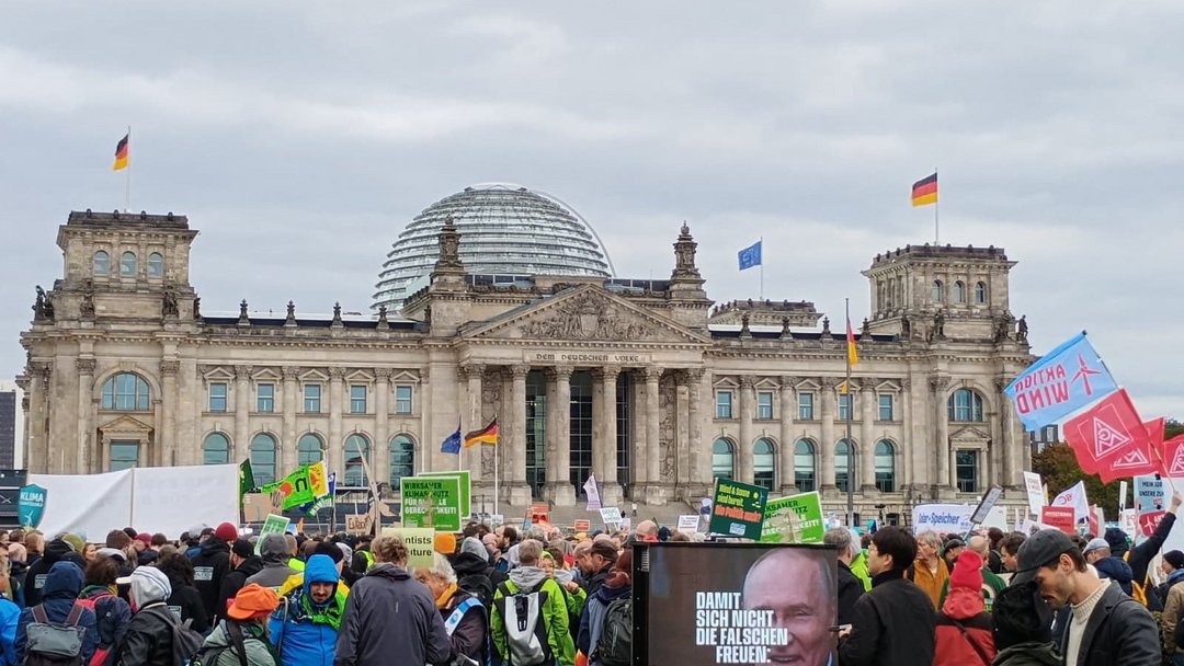Zahlreiche Plakate und Schilder der Erneuerbaren Energien und eine Menschenmenge vor dem Reichstag.