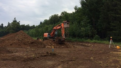 Bagger hebt in einer Baugrube Erde aus