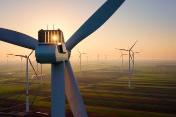 Windräder aus der Vogelperspektive bei nebeligem Sonnenaufgang