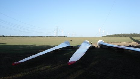 Drei Rotorenblätter liegen auf dem Boden