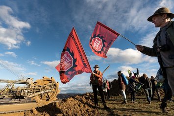 Eine Gruppe demonstrierender Menschen an der Abbruchkante des Braunkohlerevier Lützeraths.