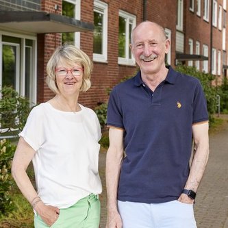 Silke Brandt und Hans-Jürgen Kohlert vor einem Mietshaus