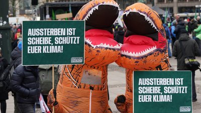 Demonstrant:innen von Green Planet Energy als Dinosaurier verkleidet beim Klimastreik in Hamburg