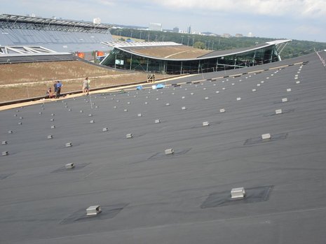 Ein Dach, bestückt mit vielen, quadratischen Metallstützen für Photovoltaikmodule.