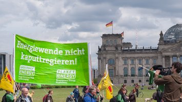 Green Planet Energy Mitarbeiter:innen demonstrieren mit Transparenten vor dem Bundestag