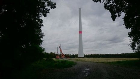 Montage einer Windkraftanlage mit einem Wald im Hintergrund.