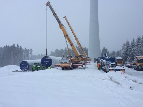 Zwei Kräne heben Stahlrohrturmsegment an