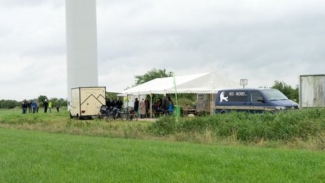 Infostände vor einer Windkraftanlage