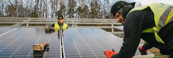 Zwei Arbeiter an einer Photovoltaikanlage